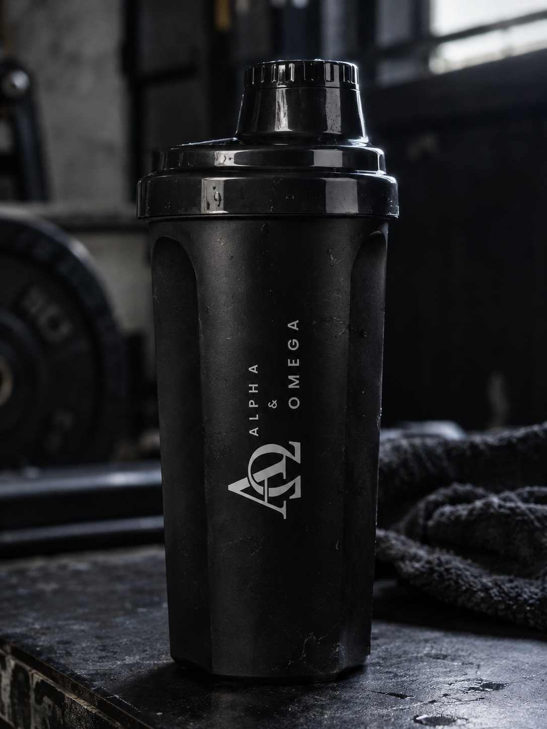 Zwarte Alpha & Omega-shaker op een bank in de gym